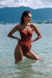 © Detkov D - Tanned girl standing in the sea and looking away in a one-piece Terracotta swimsuit