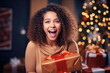 © pariketan - African woman smile shaking christmas present, happy female gets gift