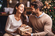 © pariketan - Couple smile shaking christmas present, happy young husband wife gift