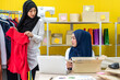 © Art_Photo - Muslim two asian woman freelancer sme business online shopping working and checklist order with cardboard box on table at home - Business online shipping and delivery concept
