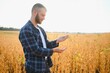 © Serhii - farmer agronomist in soybean field checking crops. Organic food production and cultivation