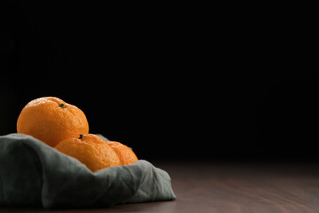 Wall Mural - Organic tangerines on a linen napkin on a wood table