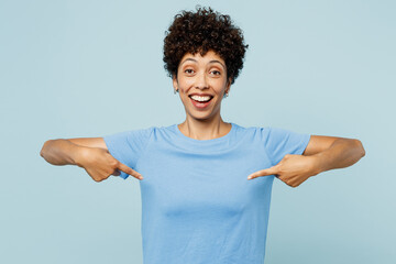 Wall Mural - Young surprised fun happy woman of African American ethnicity wear t-shirt casual clothes point index fingers on herself isolated on plain pastel light blue cyan background studio. Lifestyle concept.