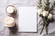 Empty white sheet of paper with white rosses and candle on the table. Copy space.