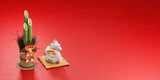 赤い背景に置かれた白い龍の小物と門松 / コピースペースのあるお正月・年賀状・新春の背景イメージ / 3Dレンダリング