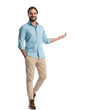 © Viorel Sima - happy casual guy with hand in pocket smiling and showing to side