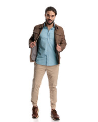 Canvas Print - cool young bearded man pulling and arranging jacket and walking