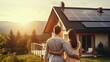 Back view of couple standing in front of new house with solar panels on roof