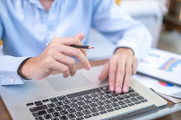 Wall Mural - Close-up freelance businessman working at indoors home office typing hand on desk computer laptop internet communication technology, human hand adult business person using laptop keyboard notebook