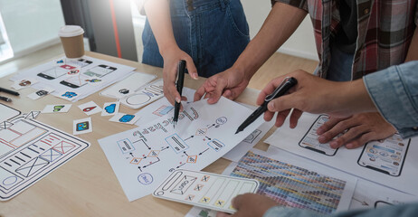A smart and handsome young Asian male website developer is talking and planning a new project with a female colleague in the office. UI, UX, Tech Startup