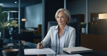 Stock Photography Capture Of A Senior Business Executive At Her Modern Office Desk, Exuding Authority And Wisdom