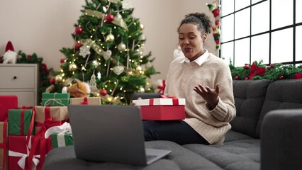 Poster - African american woman unpacking gift having video call at home