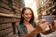 Young Caucasian Woman Taking A Picture With Her Smartphone In The City