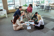 © Mediteraneo - A group of professional people sitting on the floor of the office and working together