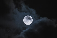 Amazing Scenery Of White Glowing Moon With Craters In Black Sky With Clouds At Night