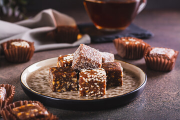 Wall Mural - Healthy candies made from figs, dates, nuts, coconut and sesame seeds on a plate