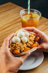 Sticker - woman's hands holding delicious Venezuelan arepa stuffed with chicken, fried plantain and corniz eggs