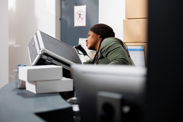 Wall Mural - Stockroom supervisor analyzing metallic box, preparing customers orders in warehouse. Storage room manager working at products delivery during merchandise inventory in storehouse