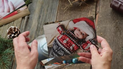 Wall Mural - Christmas photo printing. Person looks through Christmas printed photos for picture album.