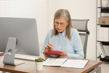 Poster - Senior accountant working at wooden desk in office