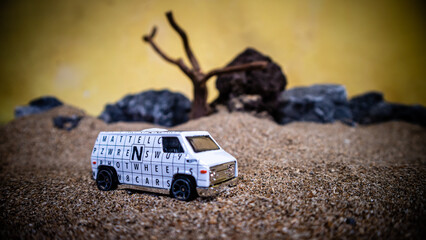 South Minahasa, Indonesia - February 2, 2023: Toy car in the sand on a yellow background looks like afternoon