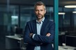 © Oleksii Halutva - Happy middle aged business man ceo standing in office arms crossed. Smiling mature confident professional executive manager, proud lawyer, businessman leader wearing blue suit