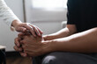© Pichsakul - Psychologist woman touching hands to encouraging man with mental health problem in therapy center