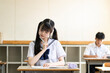 学校の教室で勉強する女子中学生