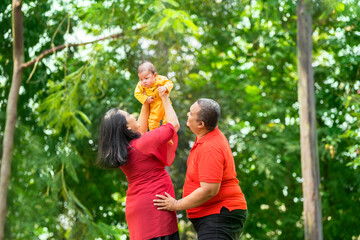 Wall Mural - Mother lifting her baby boy while father laughing