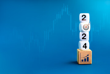 Wall Mural - 2024 new year goal and success, business resolutions and financial concepts. New year number with target icon on dices stack on growth graph on wooden cube block on blue candlestick chart background.