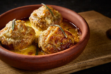 Poster - Close-up side view in horizontal format, emphasizing the savory details of meat-filled baked mushrooms, elegantly served on a Georgian clay plate