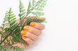 Female hand with yellow nail design. Glitter yellow nail polish manicure. Female model hand with perfect manicure