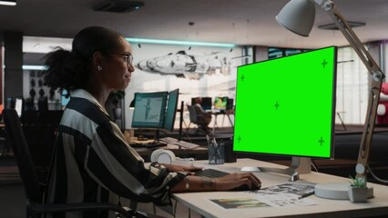 Poster - Portrait of Creative Black Woman Sitting at Her Desk Using Desktop Computer with Mock-up Green Screen Chromakey. Female Level Designer Working in Game Design Startup, Creating Immersive Gameplay.