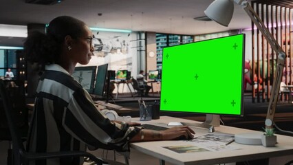 Fototapete - Portrait of Creative Black Woman Sitting at Her Desk Using Desktop Computer with Mock-up Green Screen Chromakey. Female Concept Artist Working in Game Design Startup, Creating Immersive Gameplay.