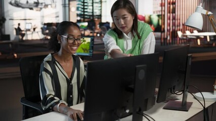 Fototapete - Asian Female Creative Director Giving Instructions on 3D Visuals to Black Female VFX Animator in Creative Agency Modern Office. Two Stylish Diverse Women Discussing Design on Desktop Computer.