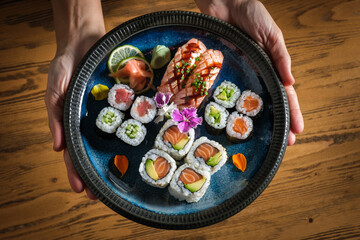 Wall Mural - Person with plate with assorted sushi