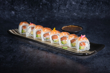 Wall Mural - Sushi rolls covered with fresh salmon served on plate