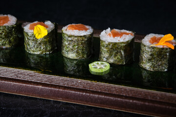 Wall Mural - Delicious sushi rolls with salmon served on wooden tray