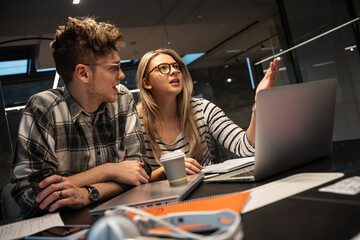 two programmers and engineers work alongside their colleagues in an office, collaborating on coding 