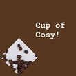 Cup of cosy text in white on brown with coffee beans on white surface