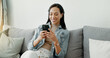 © Clement Coetzee/peopleimages.com - Woman, relax and typing on smartphone on sofa, reading social media post or mobile chat at home. Cellphone, app and download digital games, scroll connection or multimedia notification in living room