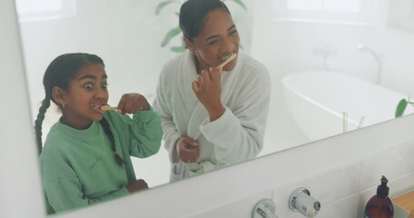 Wall Mural - Mother, learning or girl in bathroom brushing teeth together for oral hygiene on the mirror at family home. Child development, mom or kid cleaning mouth with toothbrush for dental health or wellness