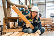 © chokniti - woman carpenter worker wearing safety uniform working to quality control checking of wooden products at workshop manufacturing. female technician making wooden in carpenter's shop industry warehouse.