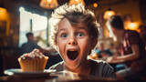 Happy smiling boy kid eats a cupcake inside a rustic restaurant