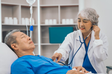 Wall Mural - Senior elderly male patient and asian people mature woman doctor, showcasing importance of healthcare expertise and patient support. caring senior doctor assisting elderly patient in hospital bed