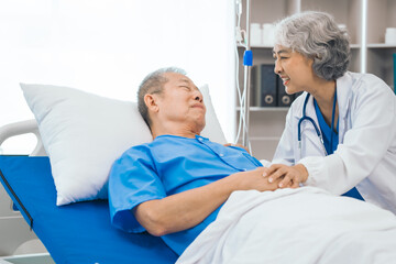 Wall Mural - Senior elderly male patient and asian people mature woman doctor, showcasing importance of healthcare expertise and patient support. caring senior doctor assisting elderly patient in hospital bed