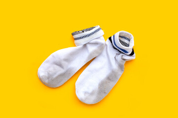 Dirty white socks on yellow background.