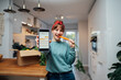 © okrasiuk - Close up focused phone with active online mobile app of Veganuary diet calendar in woman's hand, who is eating fresh carrot on her kitchen. Healthy eating, go vegan. Selective focus.