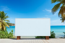 Blank White Billboard At The Beach In Front Of The Sea, Palms Trees And Blue Sky. Advertisement, Travel Concept. Mockup Banner For Publicity And Marketing.
