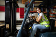© offsuperphoto - portrait female worker driving a forklift in the warehouse storage
